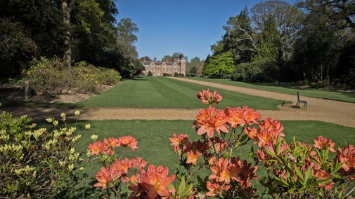 Blickling Hall viewed down Temple Walk with colourful azaleas in flower in the foreground